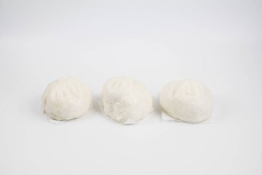 Bambu dilimleme tahtasının üzerinde domuz kıymalı buğulanmış çörekler. Beyaz arka planda Çin yemeği Dim Sum tarzı. Kahvaltı Asya yemekleri..