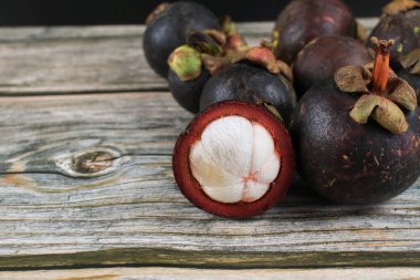 Eski ahşap arka planda mangosteen meyvesi. Meyve Kraliçesi, sulu beyaz segmentli tropikal meyve.