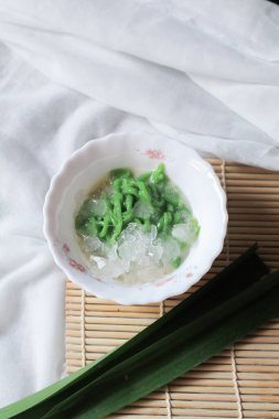 Lod Chong, yeşil pirinç unlu jöleden yapılmış. Masanın üzerinde şeker pekmezi var. Geleneksel Tayland tatlısı.