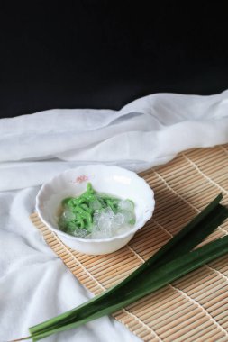 Lod Chong, yeşil pirinç unlu jöleden yapılmış. Masanın üzerinde şeker pekmezi var. Geleneksel Tayland tatlısı.