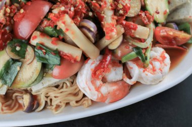 Siyah masada karides ve sebzeli baharatlı erişte salatası. Yum Mama Thai mutfağı Yum geleneksel baharatlı sıcak