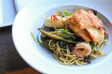 Beyaz tabakta baharatlı deniz mahsulü spagetti. Thai Style, Spagetti Pad Kee Mao. İtalyan Füzyon Yemekleri