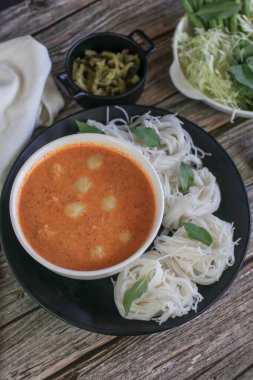 Balık soslu pirinç eriştesi ve balık köftesi sebzeyle yenir. Geleneksel Tayland yemekleri Kanom Jeen Nam Ya