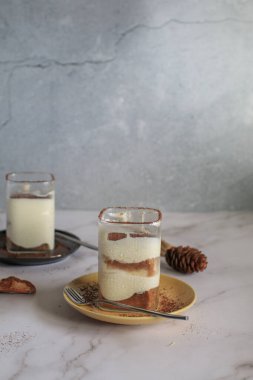 Muzlu banoffee keki, krem şanti ve karamel sosu üzerine rendelenmiş koyu çikolata serpiştirilmiş.