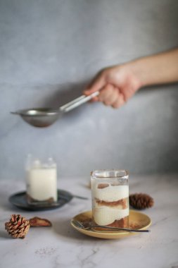 Muzlu banoffee keki, krem şanti ve karamel sosu üzerine rendelenmiş koyu çikolata serpiştirilmiş.