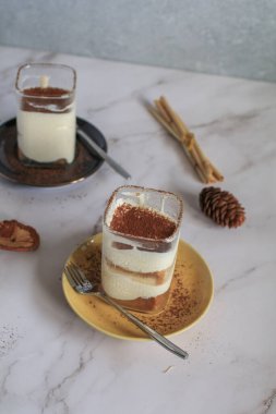 Muzlu banoffee keki, krem şanti ve karamel sosu üzerine rendelenmiş koyu çikolata serpiştirilmiş.
