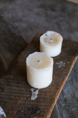 Tahtada yanan beyaz mum. Ev dekorasyonu. El yapımı. Oda spreyi. Soya mumu. Dokulu arka plan samimi bir atmosfer yaratıyor. konsept