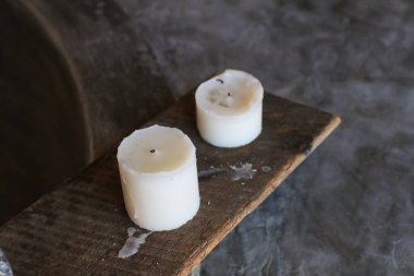 Tahtada yanan beyaz mum. Ev dekorasyonu. El yapımı. Oda spreyi. Soya mumu. Dokulu arka plan samimi bir atmosfer yaratıyor. konsept