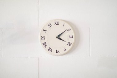 Beyaz beton arka planda asılı minimalist duvar saati. Klasik analog saat. Oturma odası tasarımı