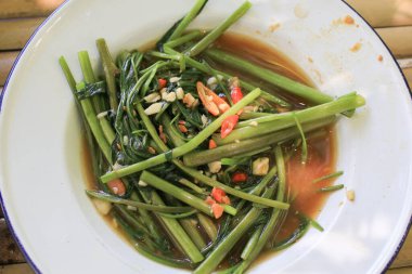 Kızarmış su ıspanağı ya da Morning Glory 'yi gün ışığında beyaz tabakta karıştır. Akşam yemeği ve kahvaltı için Tayland yemeği. Pirinç ye..