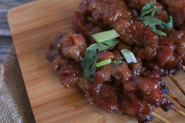 Izgara domuz şişi ya da ahşap kesme tahtasındaki yapışkan pirinçle yapılan pinpon yemeği. Popüler Tayland sokak yemekleri.