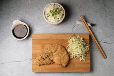 Japon tonkatsu kızarmış domuz pirzolası tarifi ile tatlı ekşi sos ve ahşap karının üzerinde pirinç. Asya yemekleri.