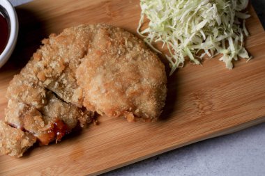 Japon tonkatsu kızarmış domuz pirzolası tarifi ile tatlı ekşi sos ve ahşap karının üzerinde pirinç. Asya yemekleri.