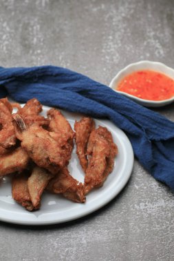 Beyaz tabakta tatlı soslu kızarmış tavuk kanadı. Aperatif Asya yemeği. Ticari kuruluşlar veya markalar için reklam.
