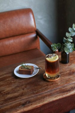 Antika kahve dükkanının ahşap masasında muzlu ekmekli Americano limon toniği. Tatlı ve yaz içeceği..