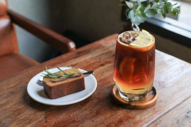 Antika kahve dükkanının ahşap masasında muzlu ekmekli Americano limon toniği. Tatlı ve yaz içeceği..