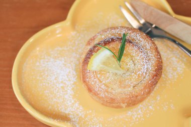 Limonlu börek ya da turta dilimli ve biberiyeli sarı tabakta. Lezzetli Yaz tatlısı.