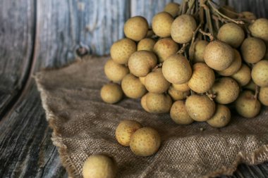 Kahverengi arka planda taze Longan meyveleri. Dimocarpus longan. Tropik meyve.