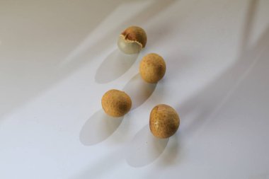 Beyaz masada güneş ışığı altında taze doğal Longan meyveleri. Dimocarpus longan. Tropik meyve.