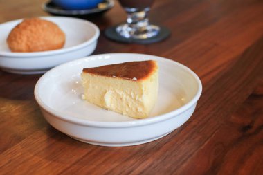 Beyaz tabakta Bask peynirli keki. Ev yapımı tarifle taze pişmiş. Kahve dükkanında lezzetli bir tatlı..