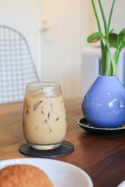 Kahve dükkanında ve restoranda yeşil bitkiyle birlikte buzlu kahve. Yağmurlu günlerde sabah kahvaltısı rutini.