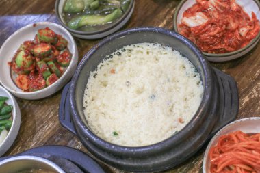 Kore buğulama yumurtası, toprak kâse ve ahşap masada ev usulü tabaklar. Kore geleneksel yemekleri.