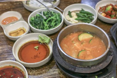 Restorandaki ahşap masada sebze soslu soya fasulyesi güveci. Geleneksel Kore yemekleri. Doenjang yahnisi.