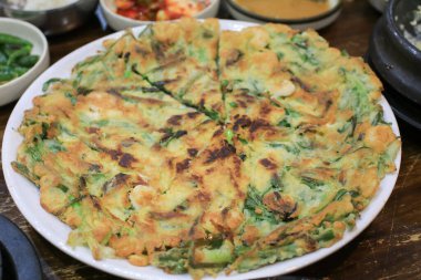 Pajeon ya da Kore Scallion Pancake 'i soya sosuyla birlikte beyaz tabakta yer. Asya yemekleri. Ev yapımı gelenek yemekleri..