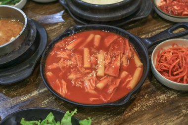 Tteokbokki Korelisi (Baharatlı Kore Pirinçli Kek Erişte Çorbası) çeşitli sebzelerle kızartılmış ve sıcak tavada baharatlı.