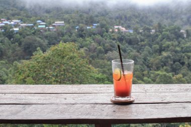 Orman dağlı ahşap terasta buzlu limon çayı. Doğada ferahlatıcı içecek..