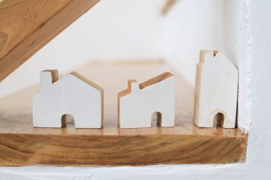 Merdivenin altındaki rafta küçük ahşap bir ev. Ev dekorasyonu. Modern minimal tasarım.