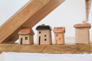 Merdivenin altındaki rafta küçük ahşap bir ev. Ev dekorasyonu. Modern minimal tasarım.