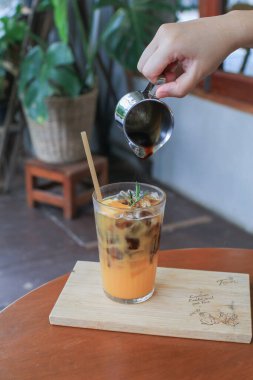 Ahşap masada portakal suyuna atılmış el yapımı espresso. Buzlu moda yaz kahvesi..