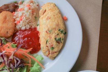 Sağlıklı Omlette Amerikan kahvaltısı, kızarmış pirinç ve beyaz tabakta ketçap. Geleneksel lezzetli sabah yemeği.