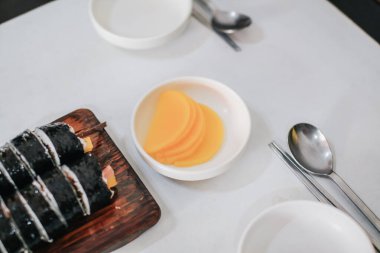 Sarı turp ya da beyaz tabakta Kimbub ile Danmuji. Kore geleneksel yemekleri.