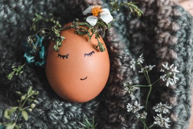 Örgü şapkalı küçük şirin bir kız çocuğu ve çiçekli örgü bir süveter..