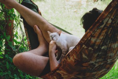 Bir kadın ve bir adam bir hamakta bir kediyle