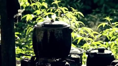 Kirli bir mutfaktaki pirinç tenceresinden buhar geliyor.