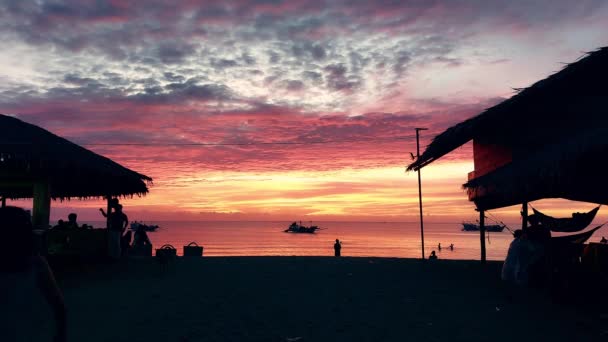 杜伦金海滩肖孔 在梦幻般的落日的天空中 船屋和野餐的人们的轮廓 — 图库视频影像