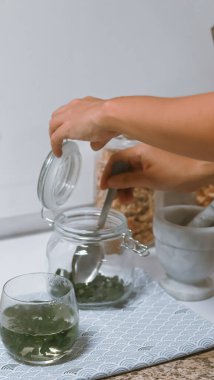 Kadın çaydanlıkta çay hazırlıyor.