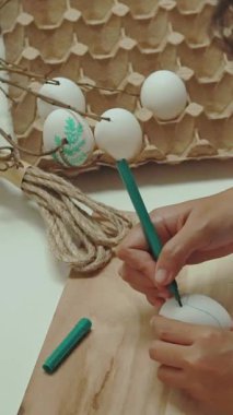 Genç bir kadın mutfakta paskalya yumurtası yapıyor.