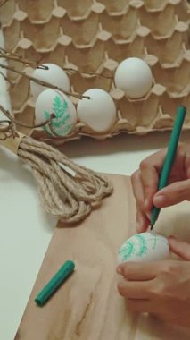 Kadın ellerinde paskalya yumurtası çiziyor..