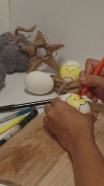 Fırçası ve beyaz yumurtası olan genç bir kadının eli..