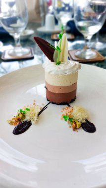 Çikolata ve kremayla süslenmiş kremalı tatlı.