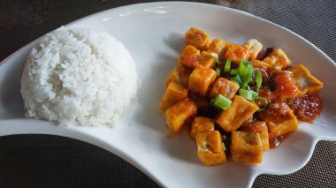 Baharatlı tofu küplerinin yanında, buğulanmış beyaz pirinç.