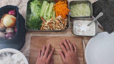 Suşi ruloları için taze sebze ve pirinç hazırlıyorum.