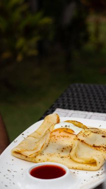 Açık havada kızarmış yumurtanın yanında servis edilen tuzlu krepler.