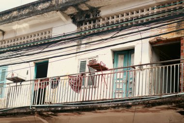 Yıkanmış apartman balkonunda dışarıda kirli çamaşırlar asılı.