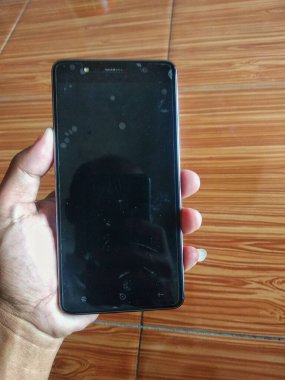 Fayans zemininde siyah ekranlı akıllı telefon..