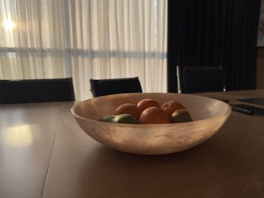 Ofiste meyve sepeti ve beyaz perdelerin arasından sabah güneşi parlıyor. Yüksek kalite fotoğraf